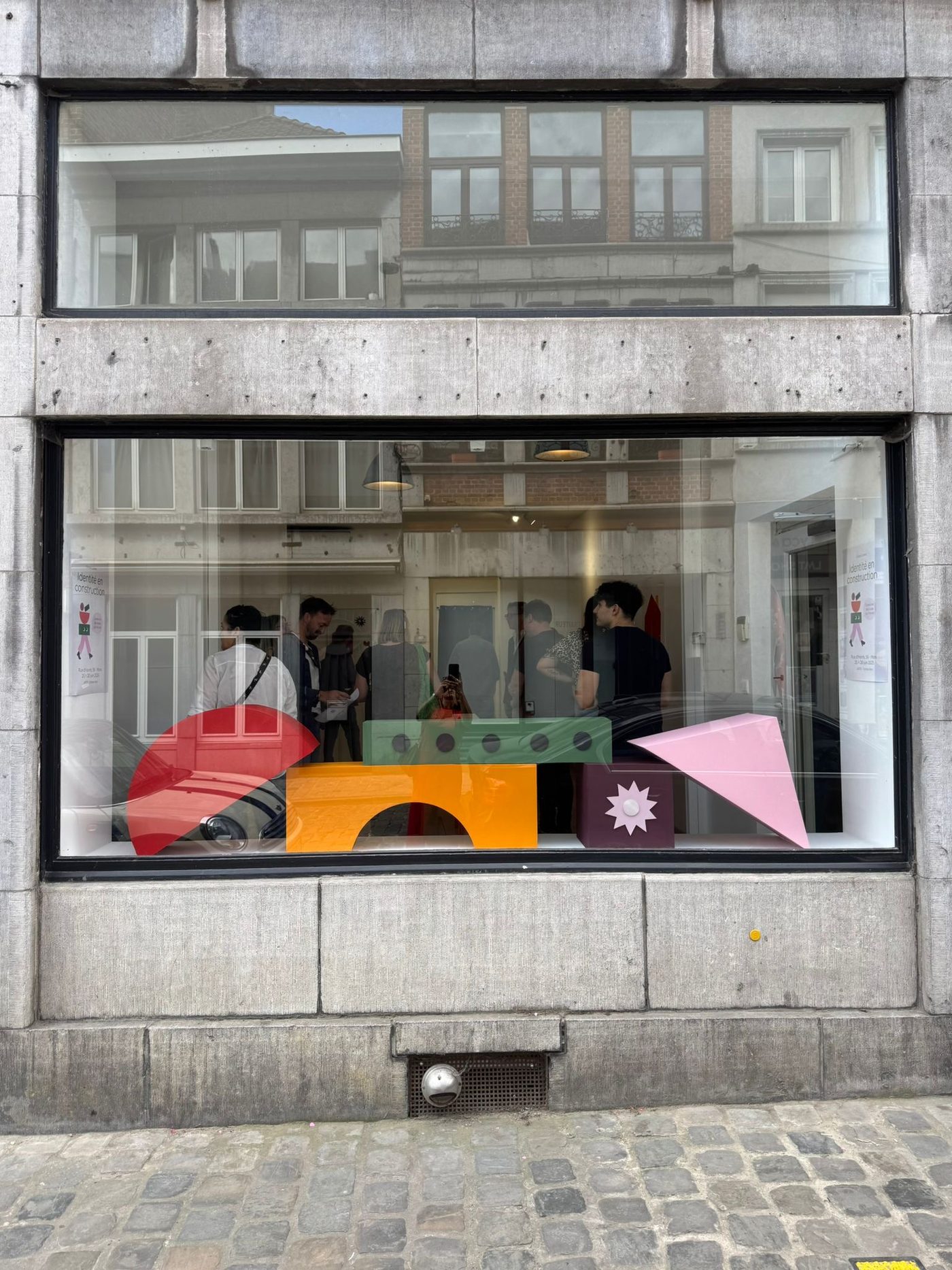 Identité en construction — les caisses colorées exposées en vitrine.